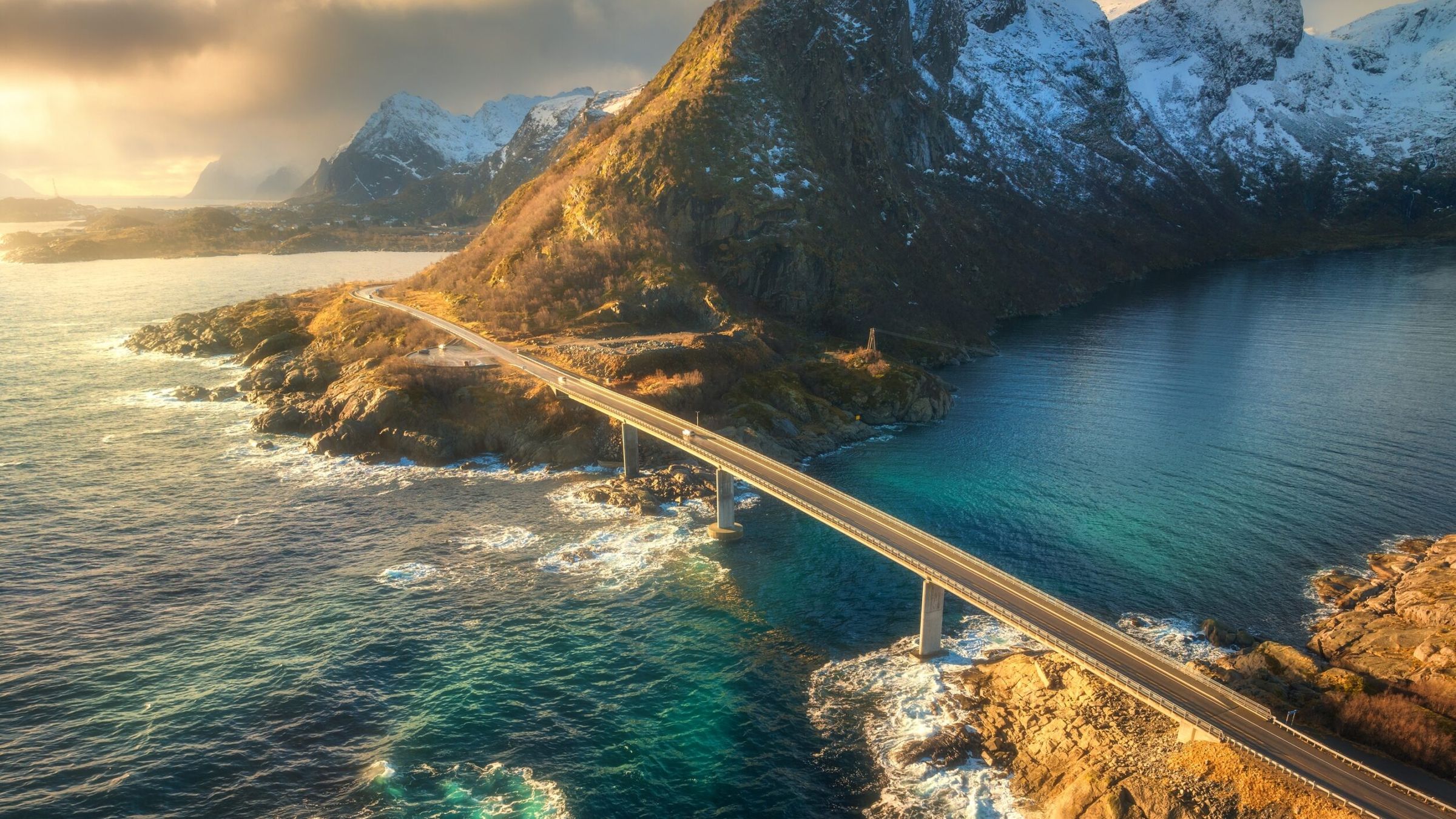 Aerial View Of Bridge Sea With Waves And Mountains At